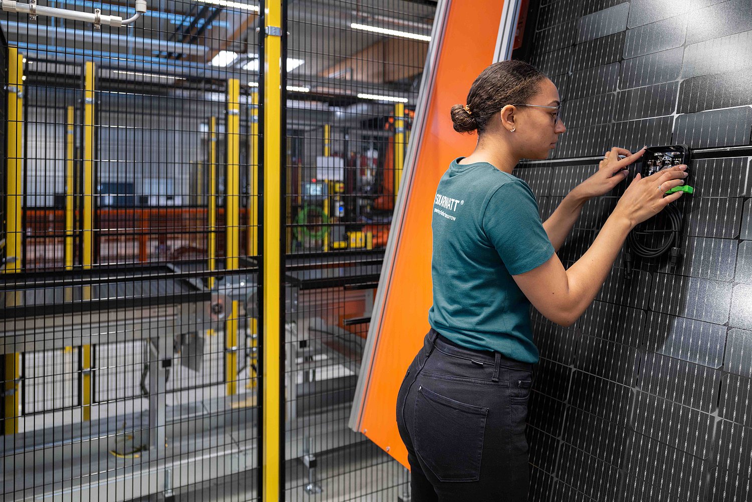Monteurin prüft Glas-Glas-Modul in der Fertigung